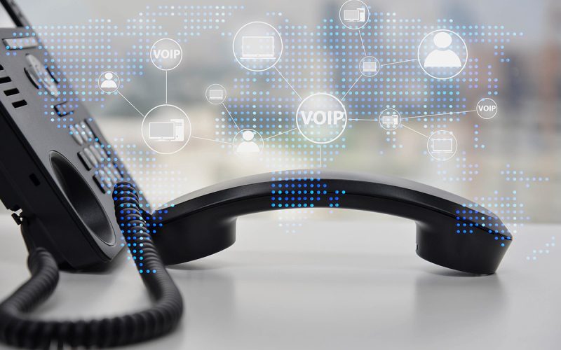 A voip phone resting on the table with all the things it can handle superimposed overtop.