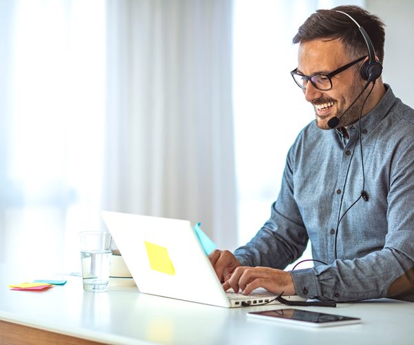 A young businessman hosting a videoconference on his laptop.