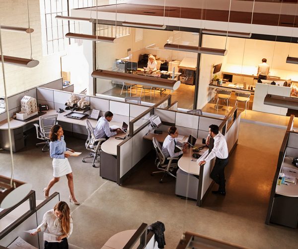 Elevated view of a busy open plan office Looking down into a large office with workers milling about.